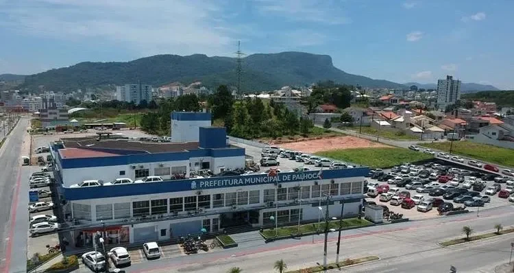 Vista aérea da Prefeitura de Palhoça, no Pagani, com casas e prédios do bairro e o morro ao fundo