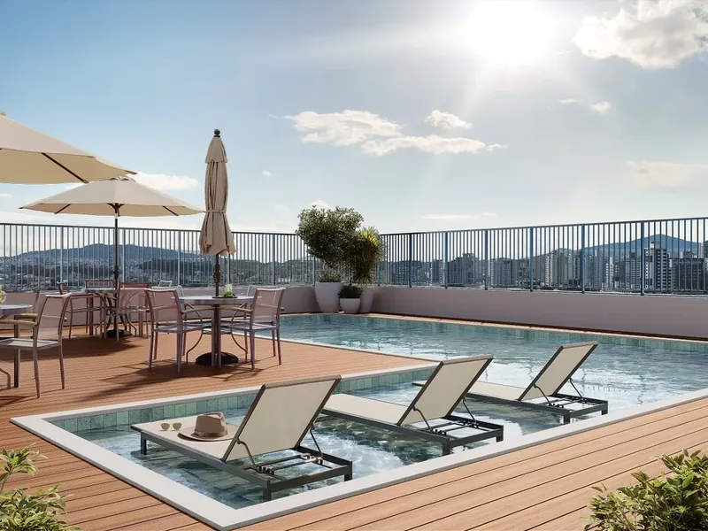 Piscina do View Residence com deck, guarda-sóis e a cidade ao fundo