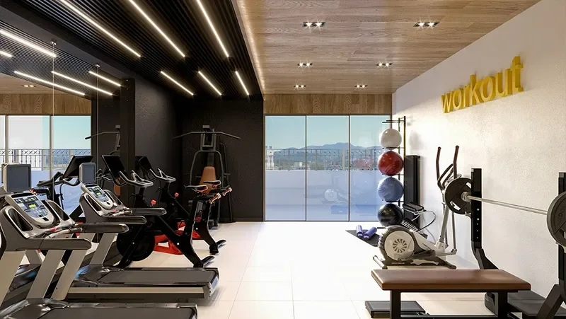 Espaço fitness do Carmel Residence com esteiras, bicicletas e estação de musculação