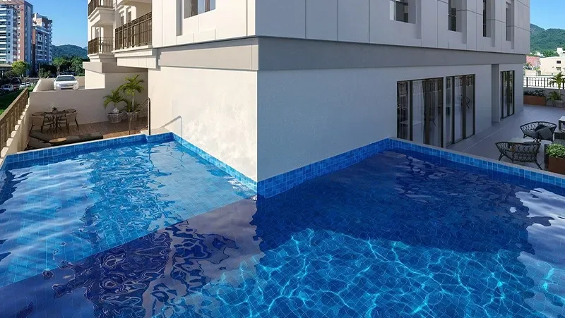 Piscina aquecida do Carmel Residence, com água azul, deck e vista para os prédios vizinhos