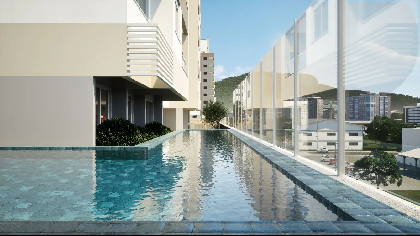 Piscina com raia do Enjoy, com deck, guarda-corpo de vidro e vista para os prédios da Pedra Branca