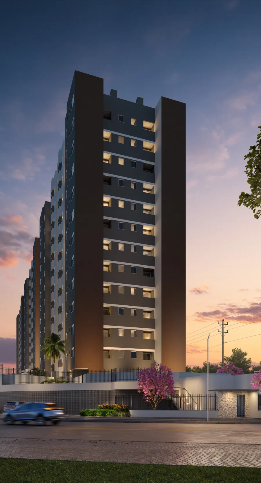 Torre do Grand Life Residence ao entardecer, com a fachada iluminada e a portaria na calçada