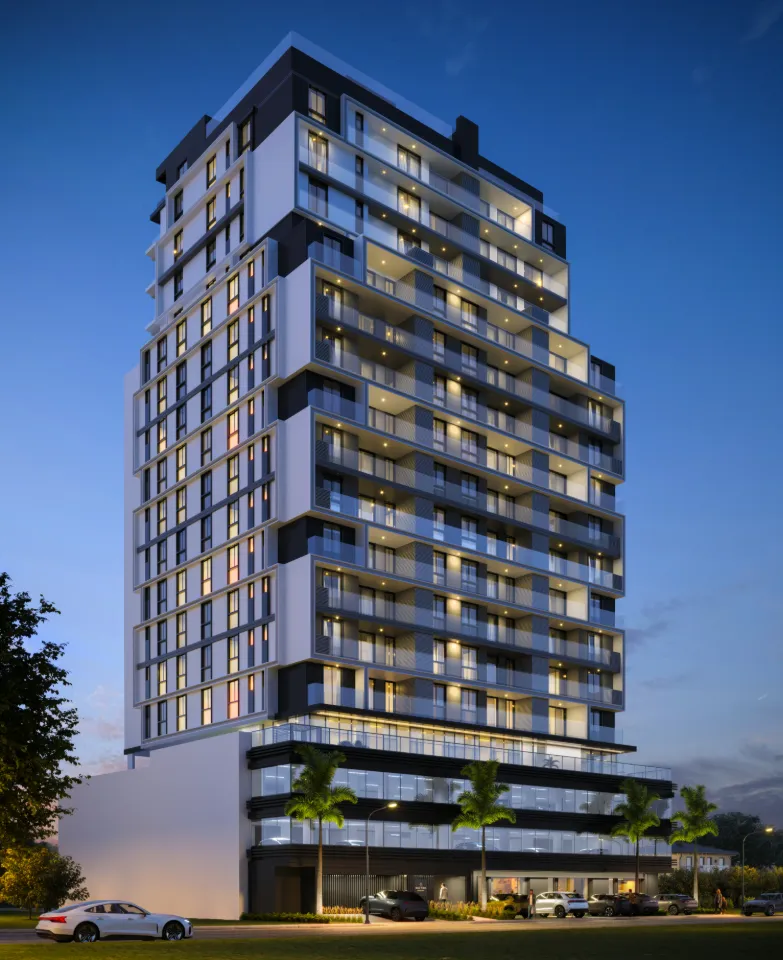 Torre do New York Residence iluminada ao anoitecer, com sacadas em vidro e embasamento comercial, na Pedra Branca em Palhoça/SC