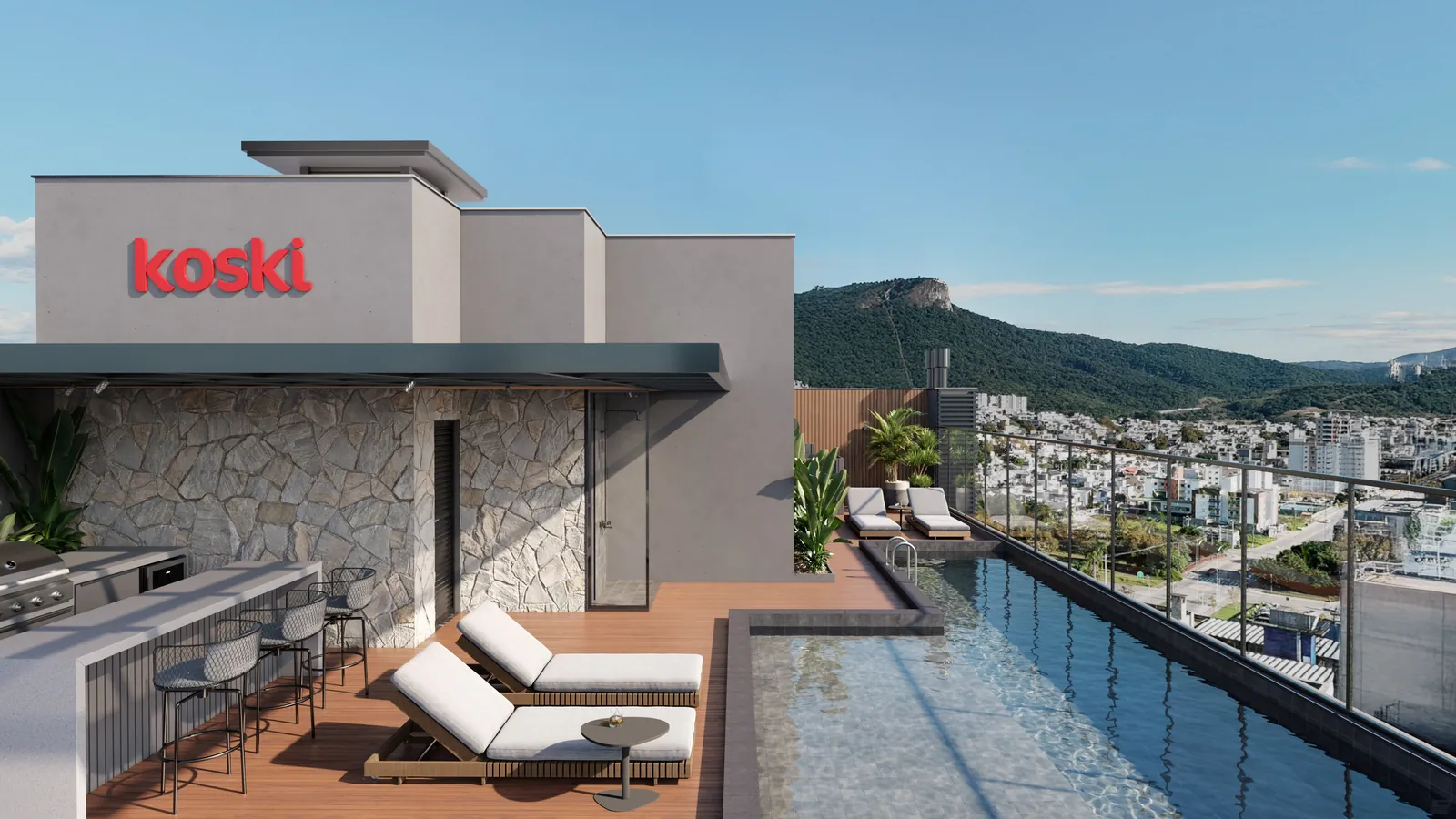 Piscina panorâmica com borda de vidro no alto do New York Residence, com espreguiçadeiras, deck e os morros da Pedra Branca ao fundo