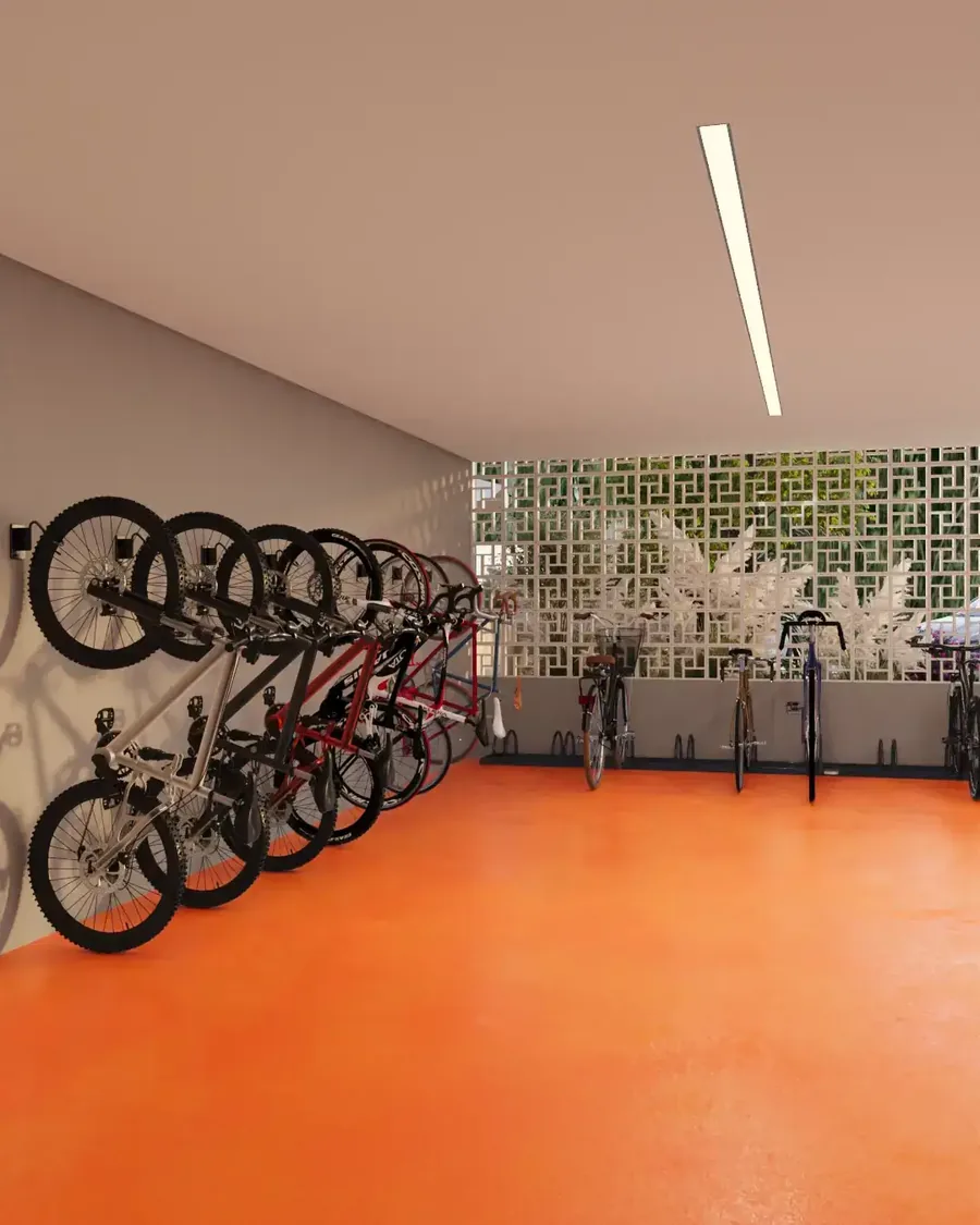 Bicicletário do Sinai Residence, com bicicletas penduradas na parede e piso laranja