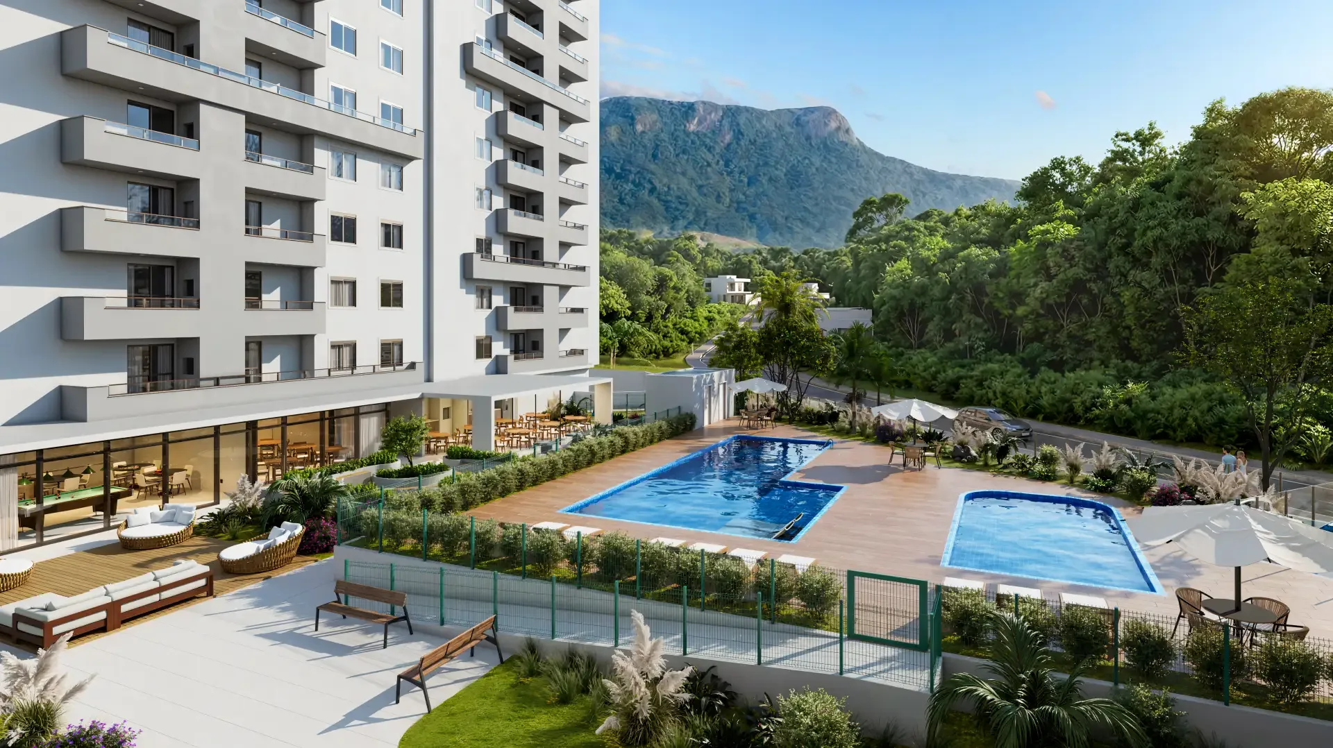Piscinas e deck do Sinai Residence ao pé da torre, com a mata e a montanha ao fundo